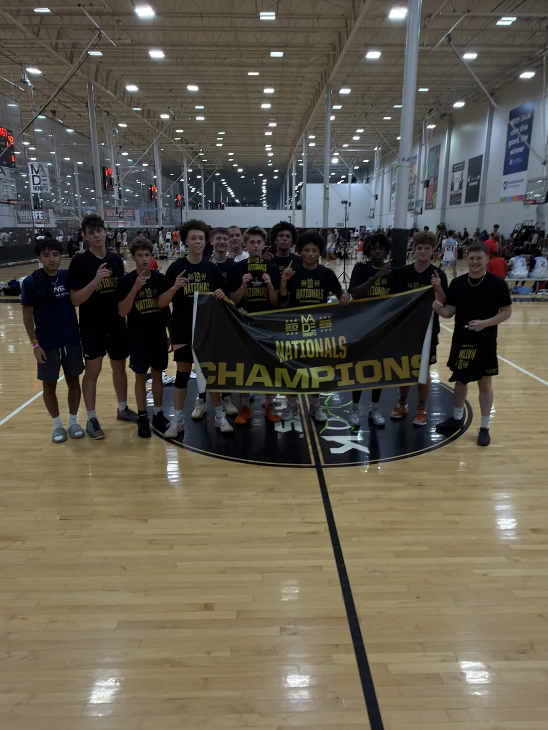 MVE 16U holding the Made Hoops Nationals champions banner at center court